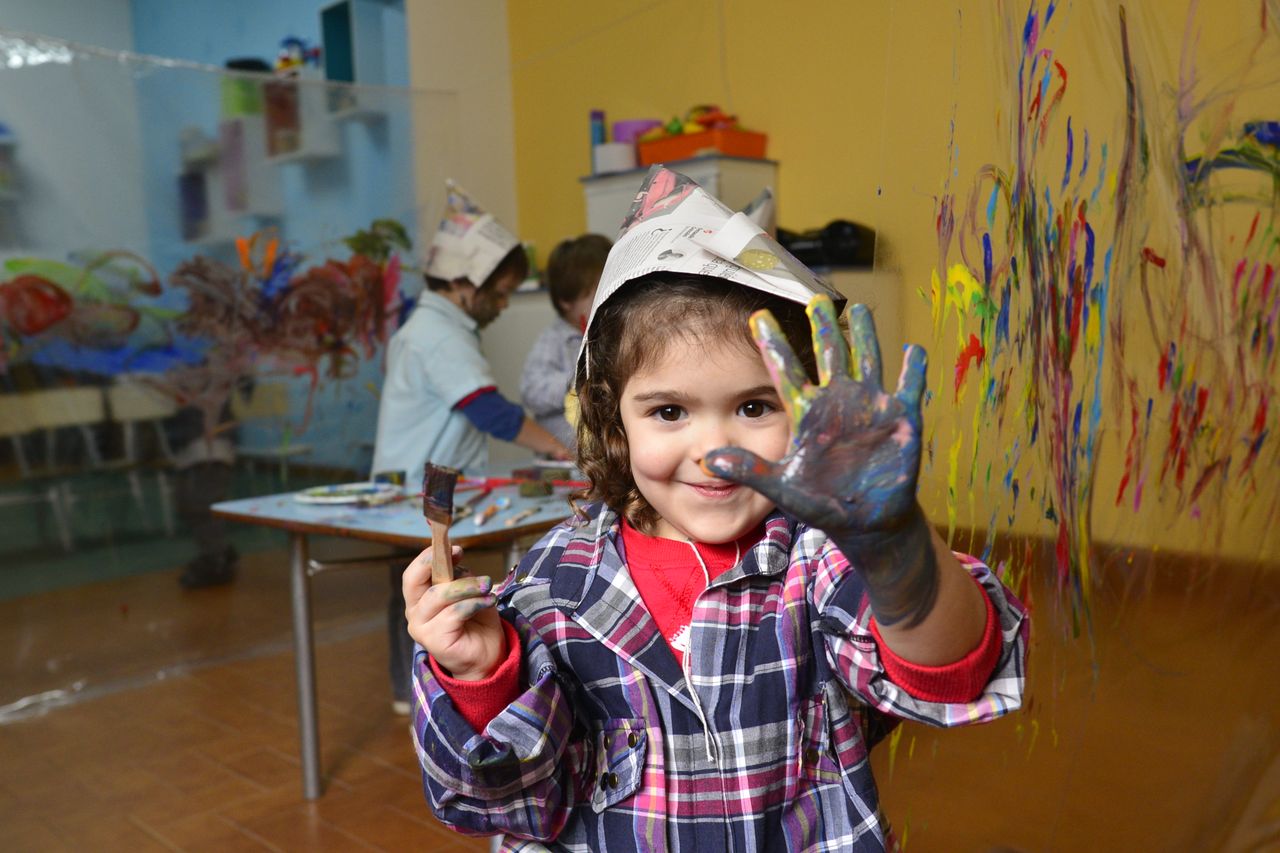Child smiling with colorful paint on their face