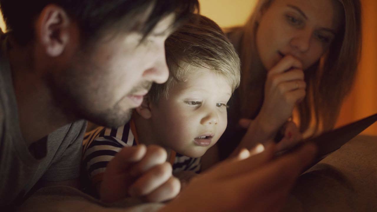 Parent and children using a tablet together